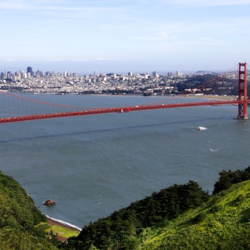 the golden gate bridge with green hills in foreground